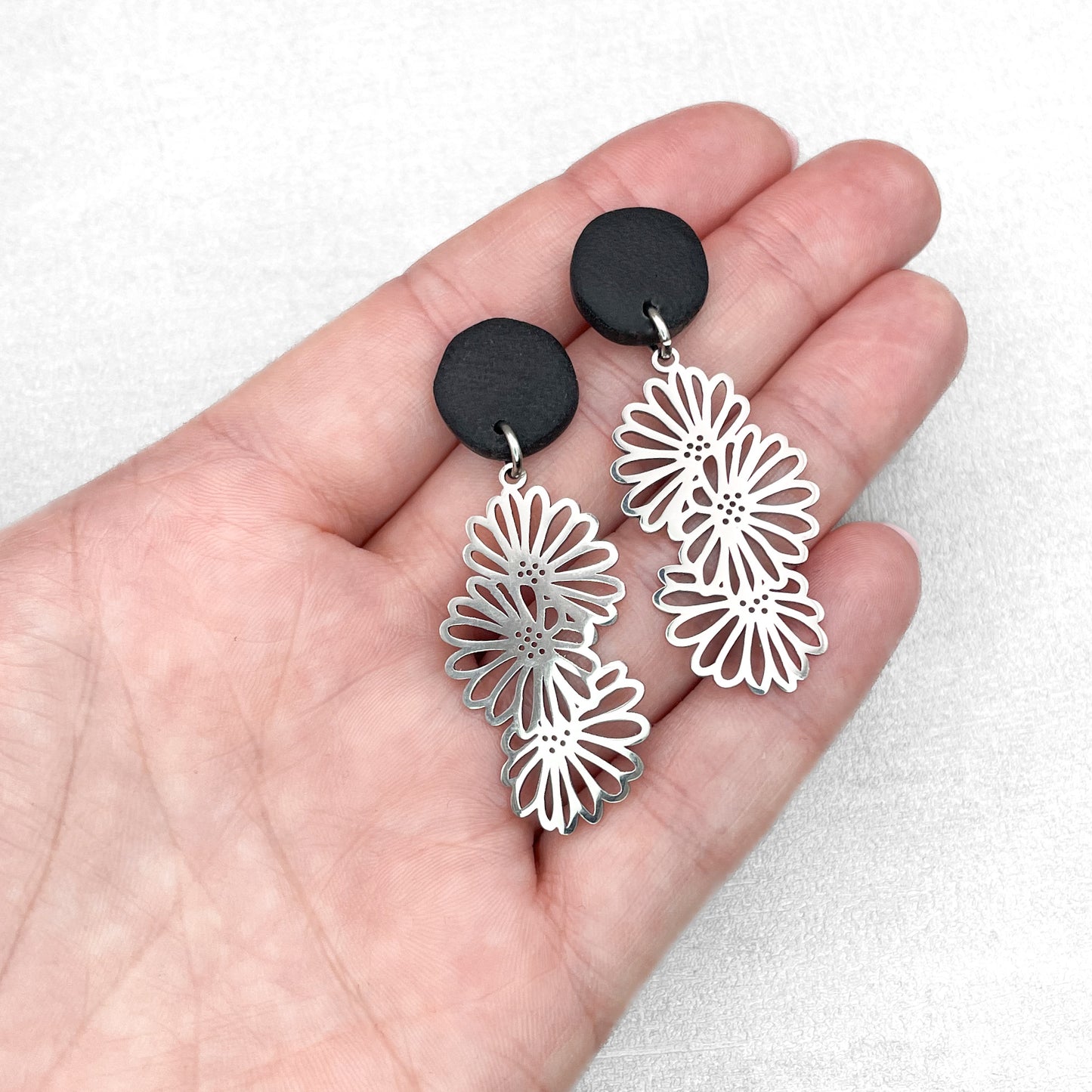 Black polymer clay with flower charms. Handmade earrings.